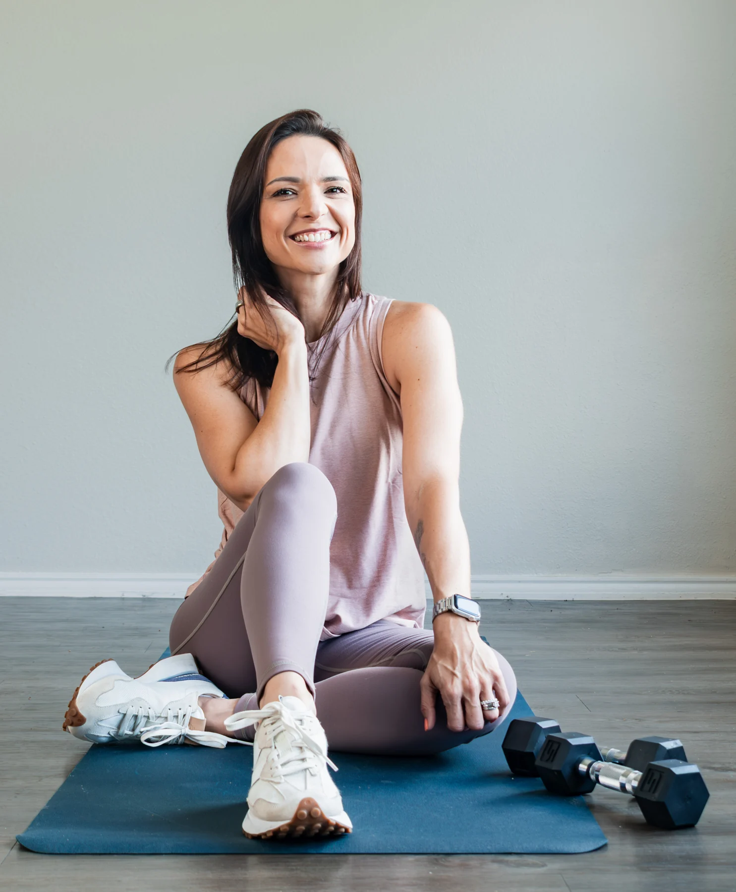 Mayra Hall sitting on a training mat in her studio